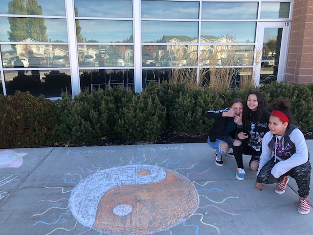 Students standing by chalk drawing for Unity Day.