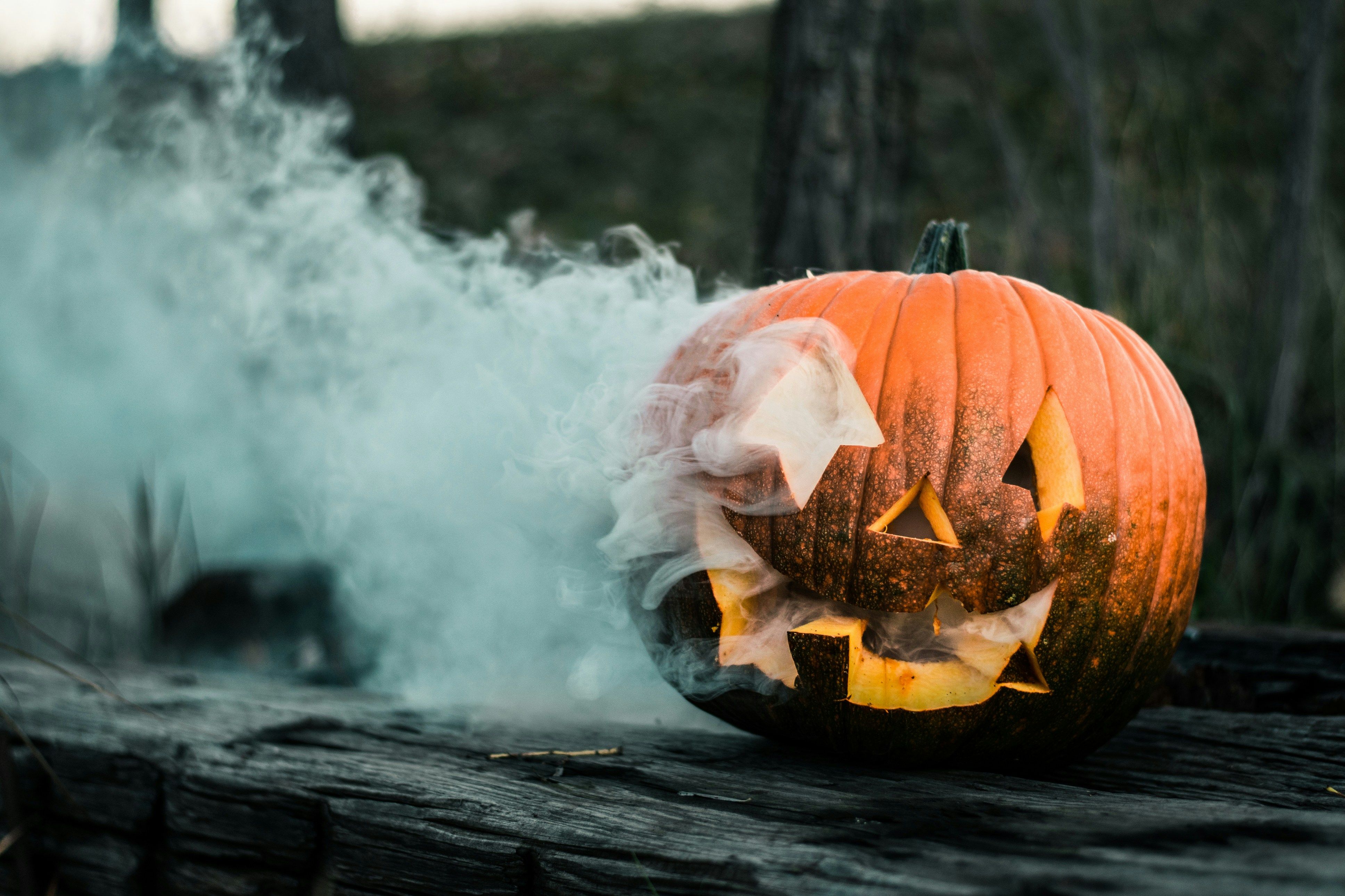 carved pumpkin with smoke coming out of it located in the outdoors